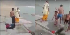 image: Pandit ji beat boys on banks of river Ganga in Rishikesh