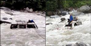 Vehicle fell from road into overflowing river